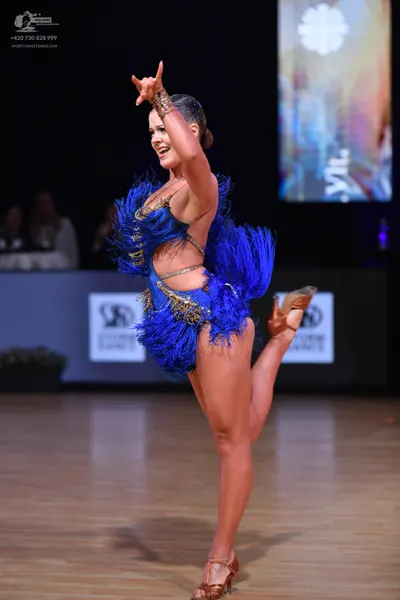 Dancesport competitor: Female dancer: blue latin dance costume with blue fringe and gold sequin/metalli