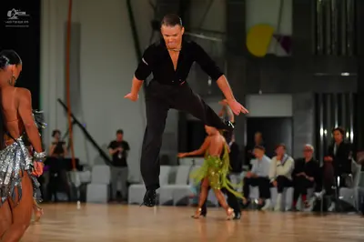 Dancesport competitor: Female dancer in foreground: silver sequined latin dress with metallic fringe