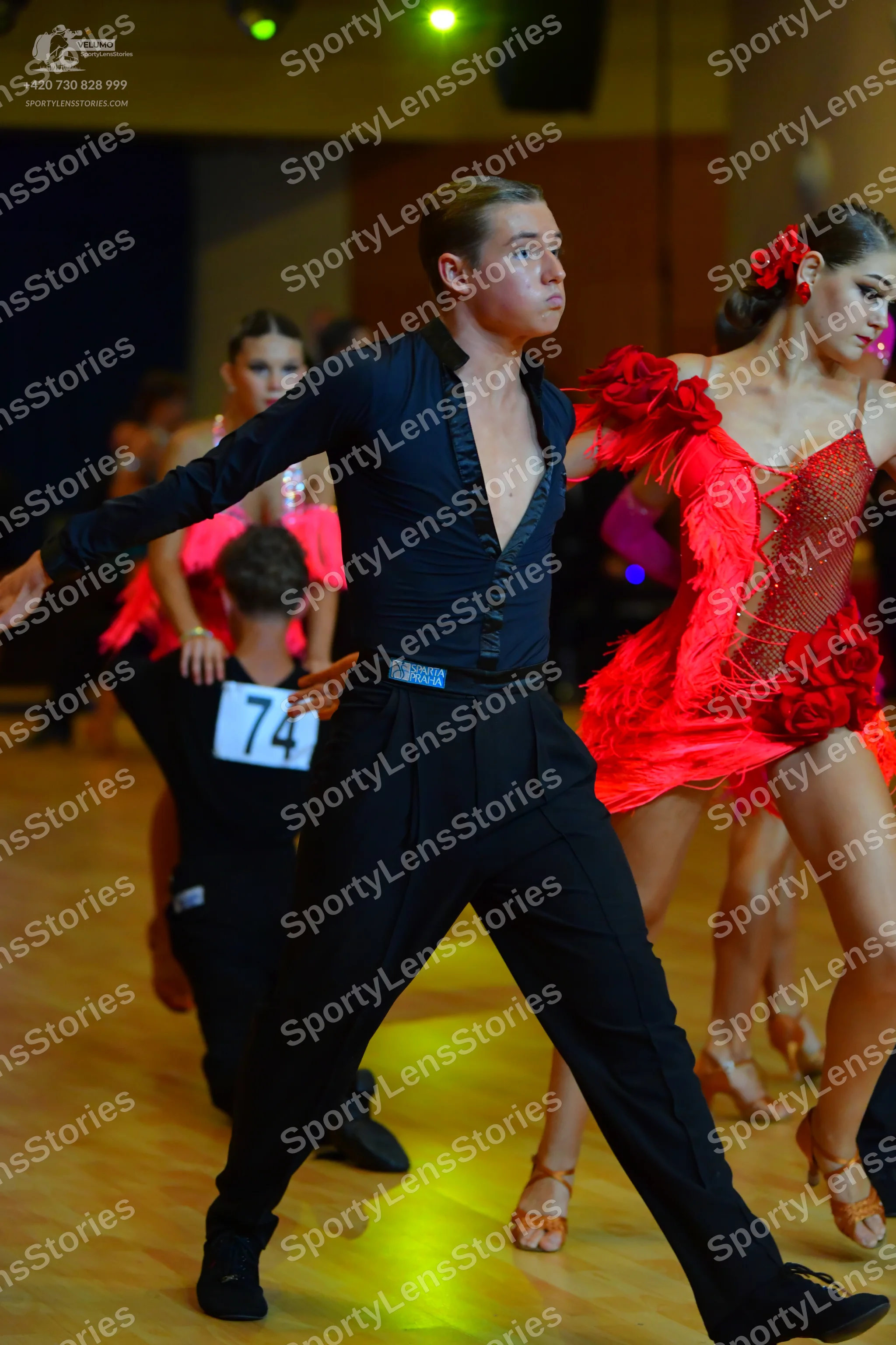Dancesport competitor #74: Male dancer in foreground: black long-sleeved shirt and black trousers