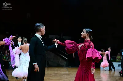 Dancesport competitor: Male dancer (foreground): black suit with white shirt and cravat