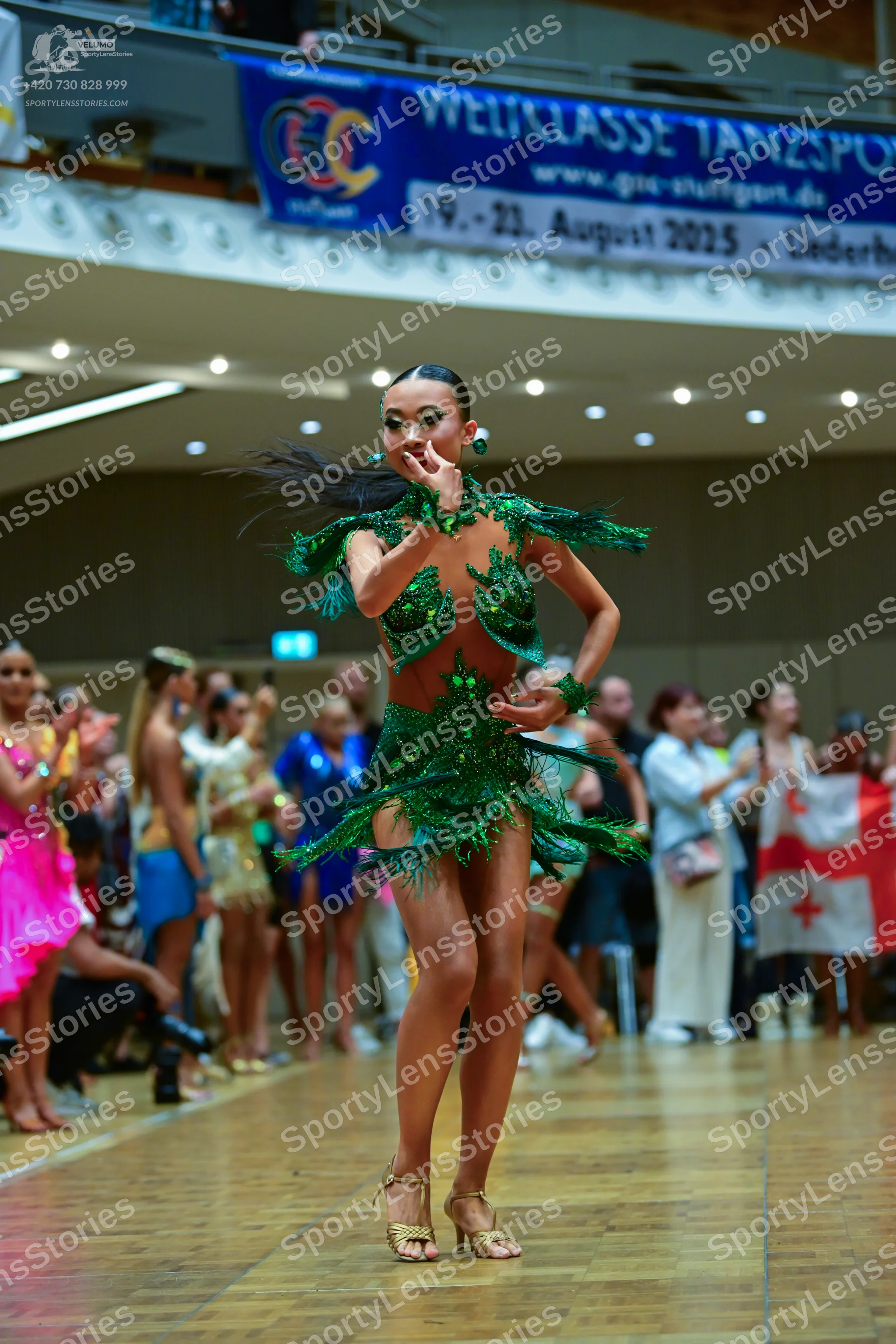 Dancesport competitor: Female dancer: green latin dress with sequins and fringe