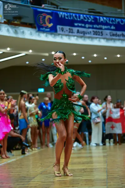 Dancesport competitor: Female dancer: green latin dress with sequins and fringe