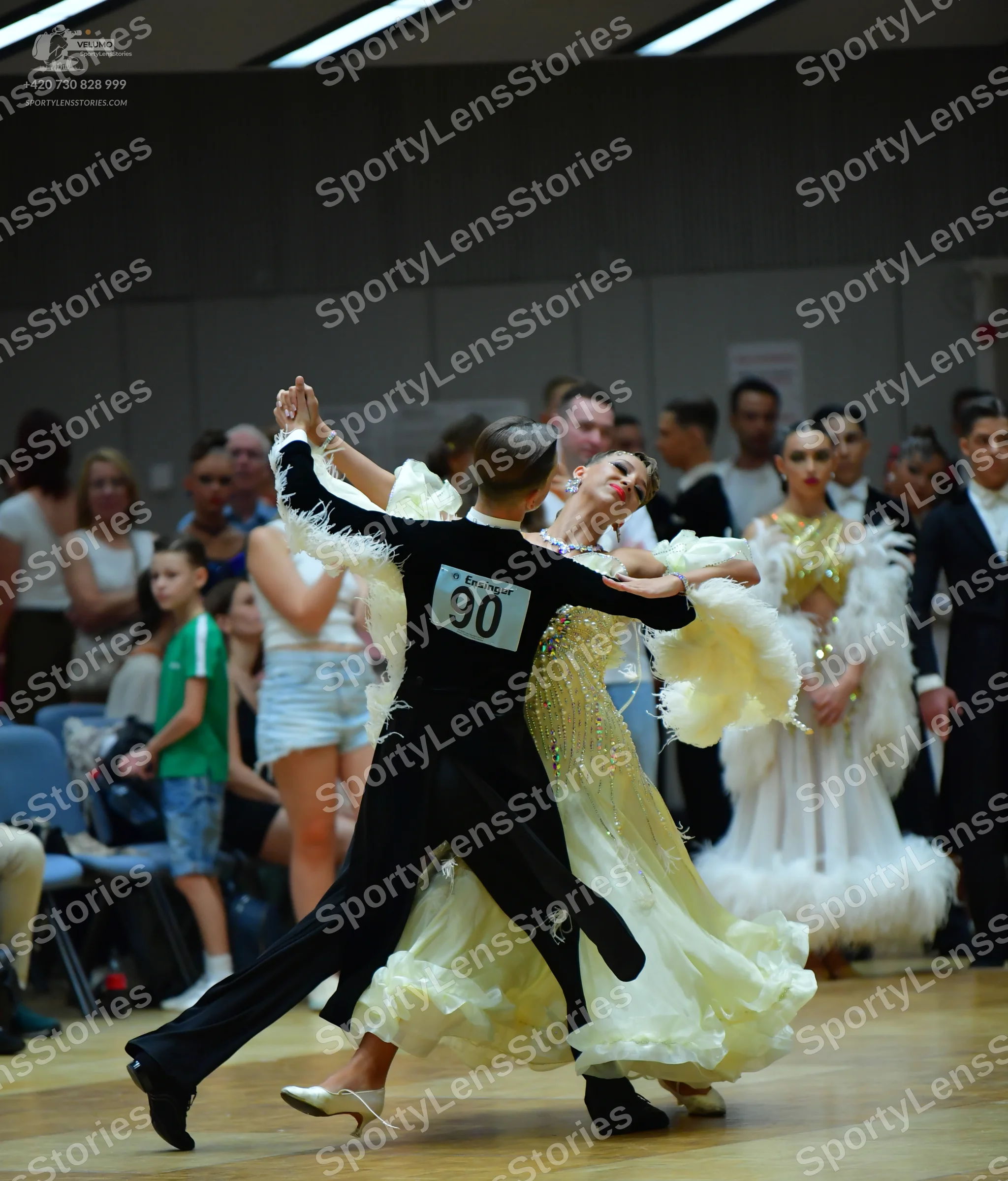 Dancesport competitor #90: Male dancer (foreground): black long-sleeved top with white feather-like trim on