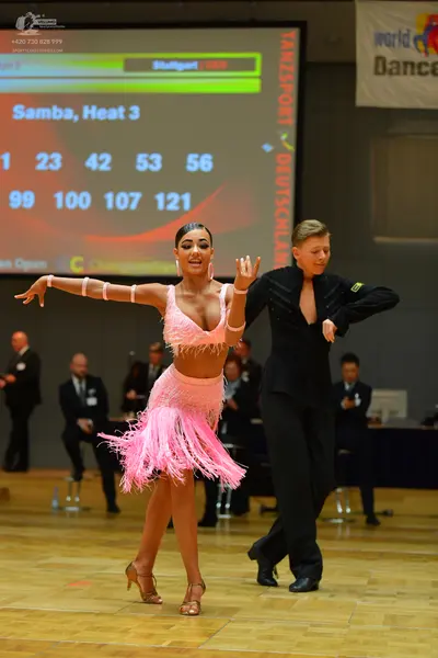 Dancesport competitor: Female dancer: light pink latin dress with fringe, hoop earrings, and bracelets