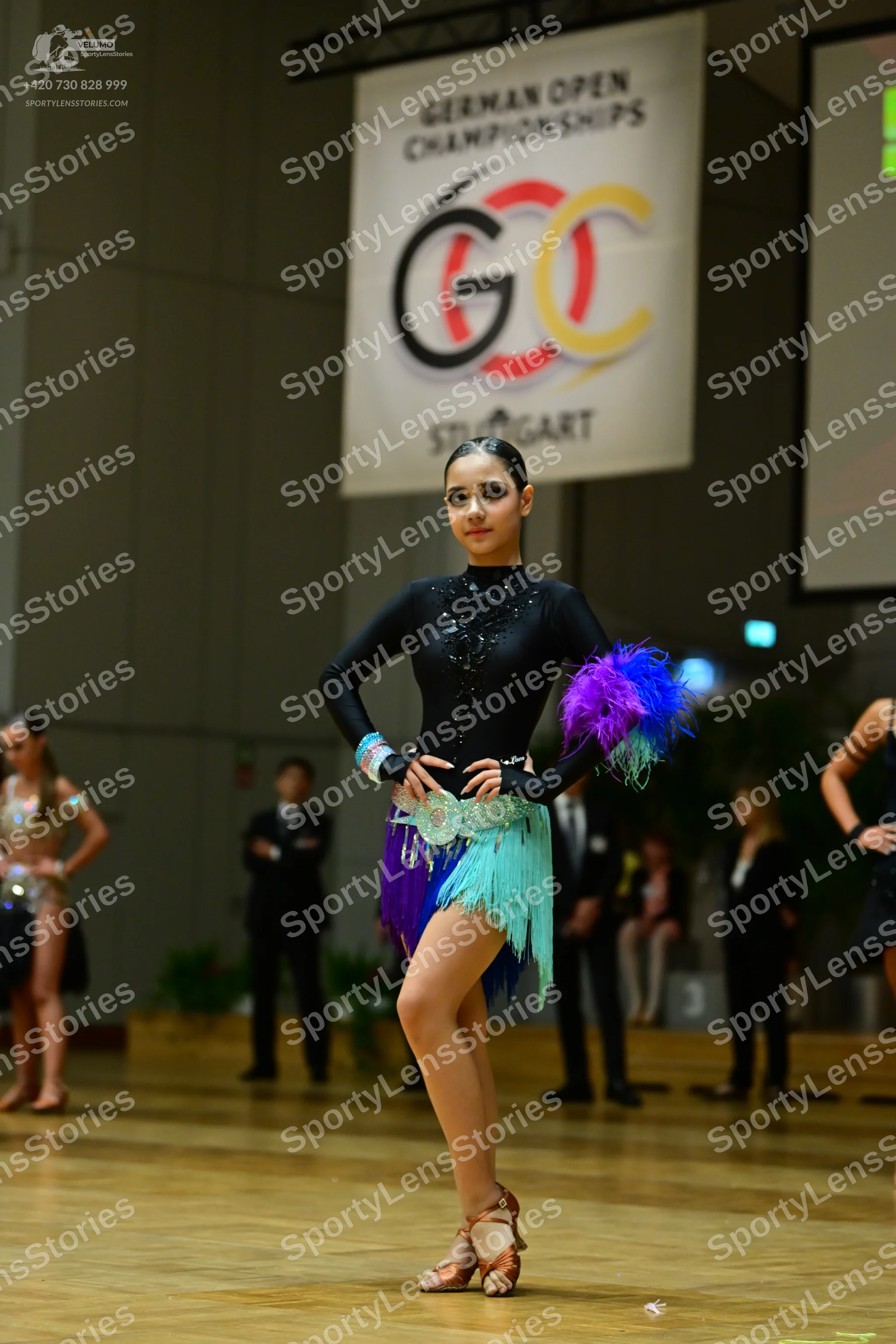 Dancesport competitor: Main female dancer: black long-sleeved latin dress with a multi-colored fringe s