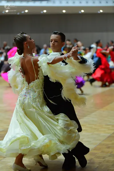 Dancesport competitor: Female dancer: pale yellow ballgown with rhinestone embellishments on the bodice