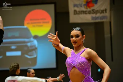 Dancesport competitor: Female dancer: purple sequin latin dress with cutouts and silver accessories