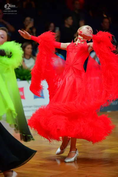 Dancesport competitor: Female dancer in red: red latin dance dress with voluminous red feather or fring