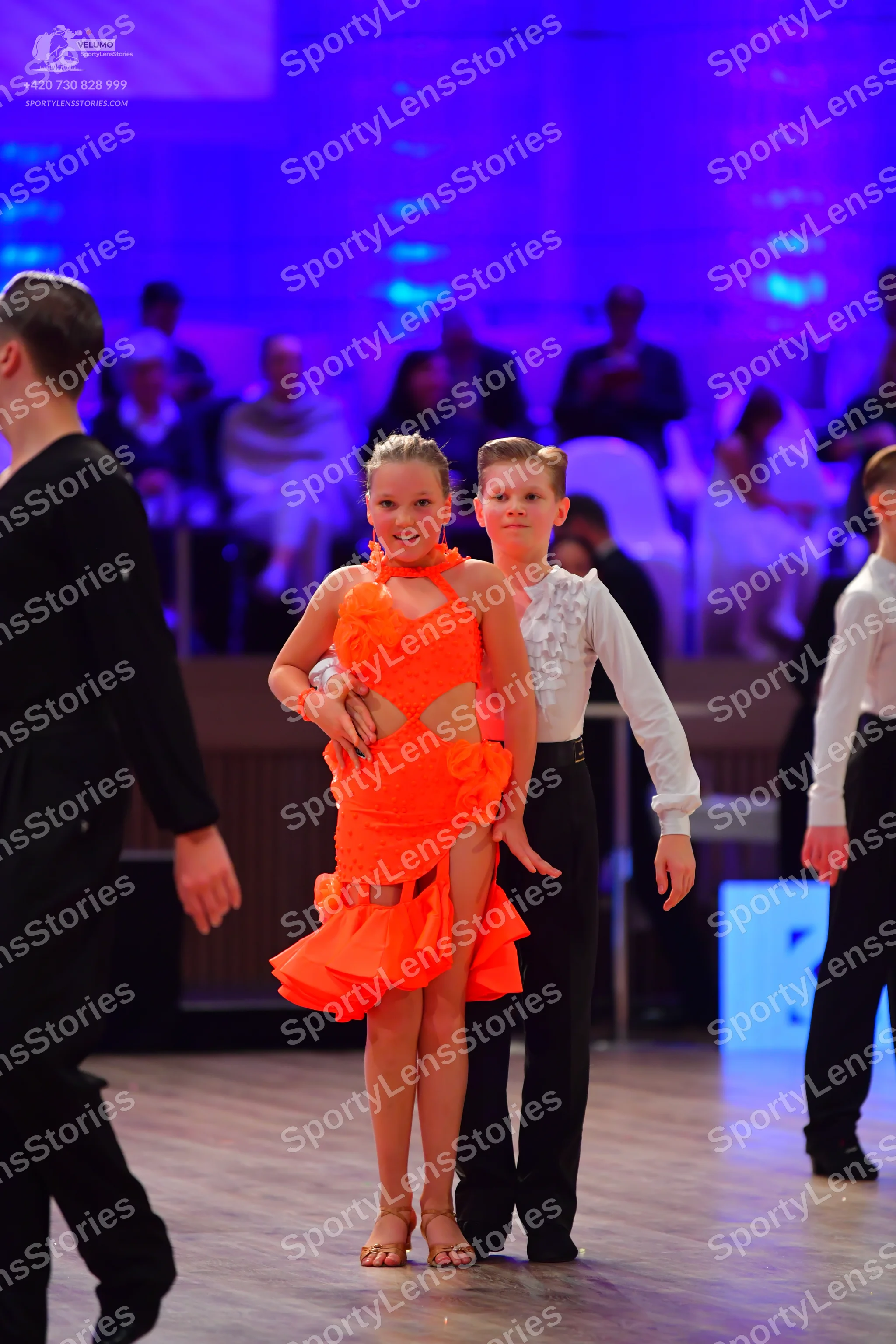 Dancesport competitor: Female dancer: orange Latin dress with ruffles and cutouts