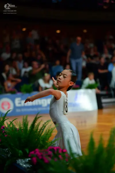 Dancesport competitor: Female dancer: white dress with a full skirt
