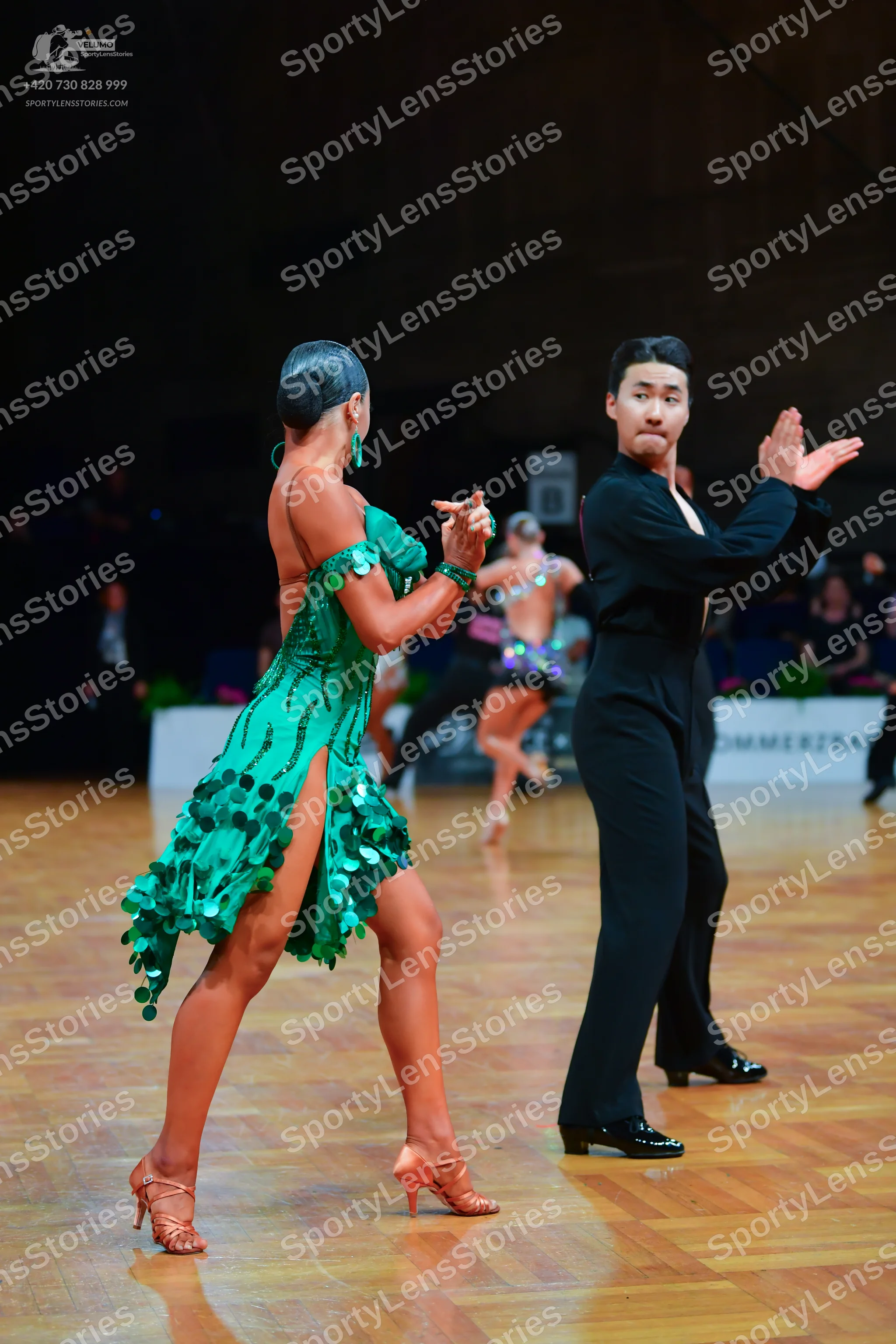 Dancesport competitor: Female dancer: green latin dress with large green sequins and a high slit