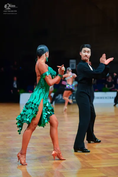 Dancesport competitor: Female dancer: green latin dress with large green sequins and a high slit