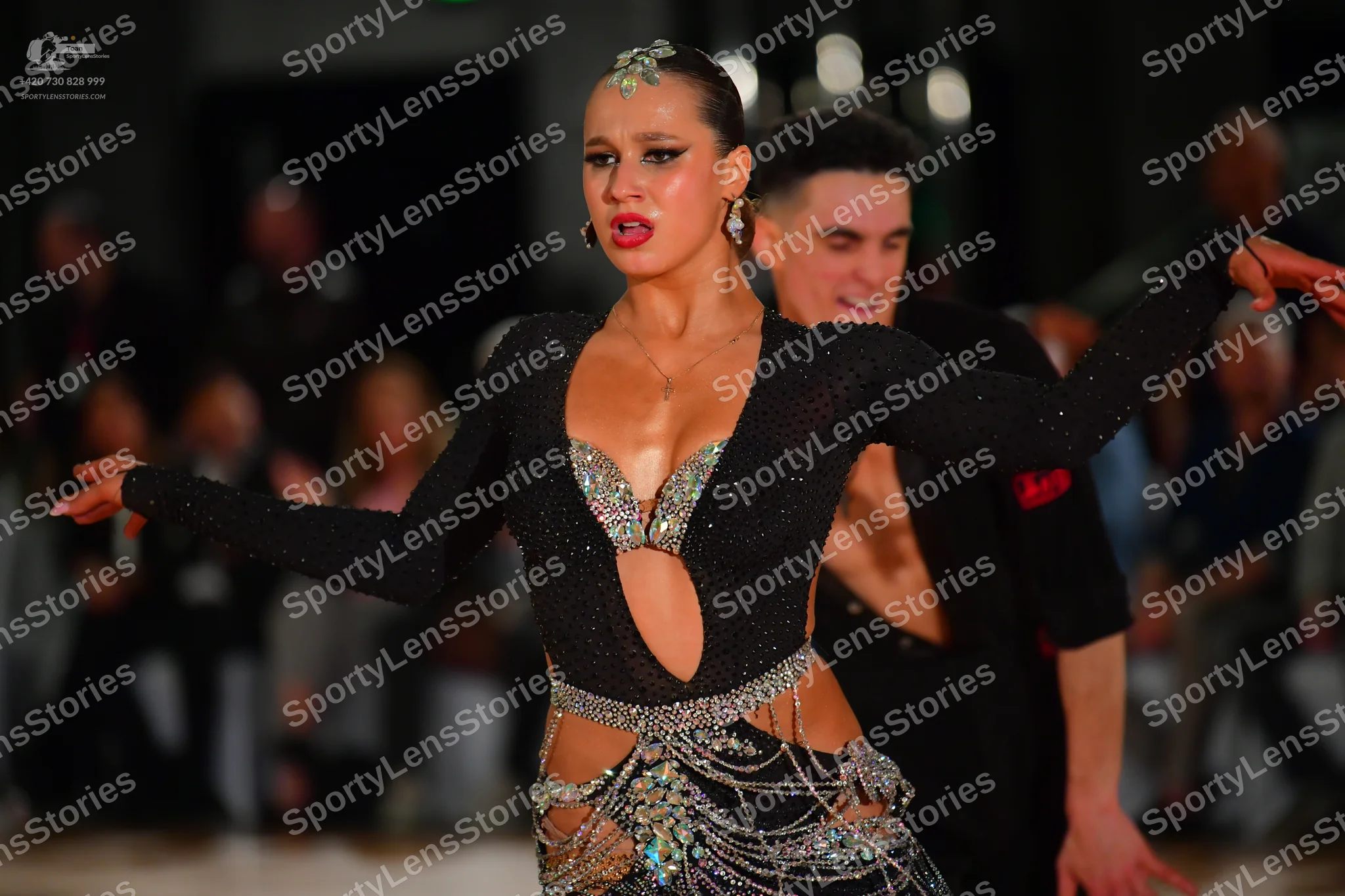 Dancesport competitor: Female dancer: black long-sleeved Latin costume with a deep V-neck, midriff cuto