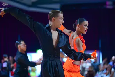 Dancesport competitor: Male dancer: black satin long-sleeved shirt with a deep V-neck and matching blac