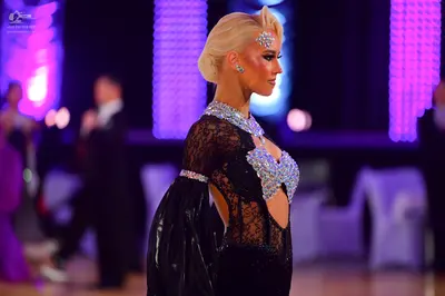 Dancesport competitor: Female dancer (foreground): black latin dress with lace, sequins, and large puff