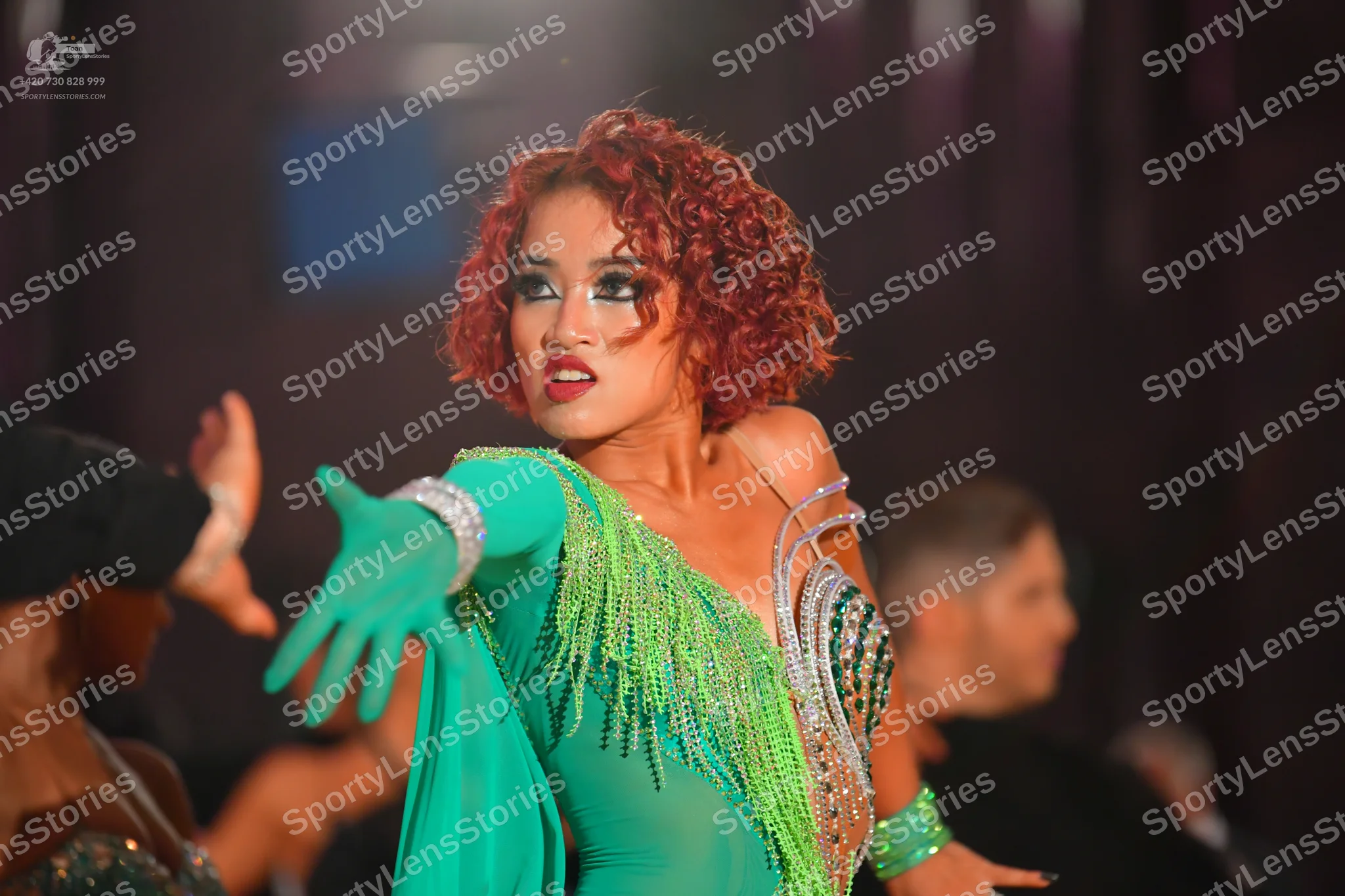 Dancesport competitor: Female dancer: bright green Latin dress with long green fringe and silver sequin