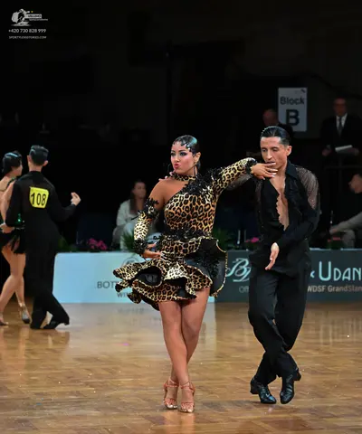 Dancesport competitor: Female dancer: leopard print latin dress with long sleeves and a ruffled skirt