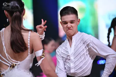 Dancesport competitor: Male dancer: white long-sleeved shirt with textured fabric and ruffled detailing