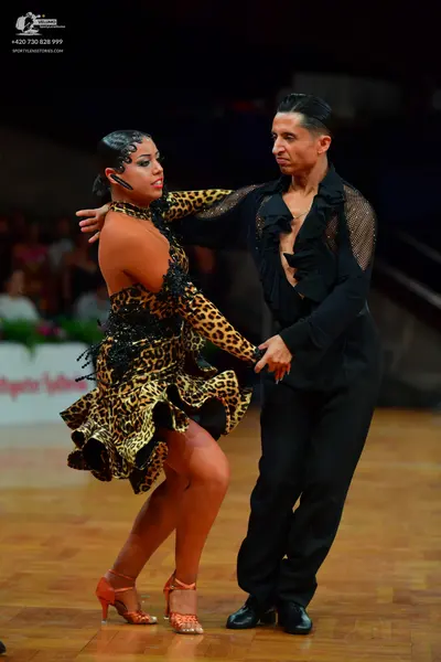 Dancesport competitor: Female dancer: leopard print latin dress with black sequin embellishments, one l