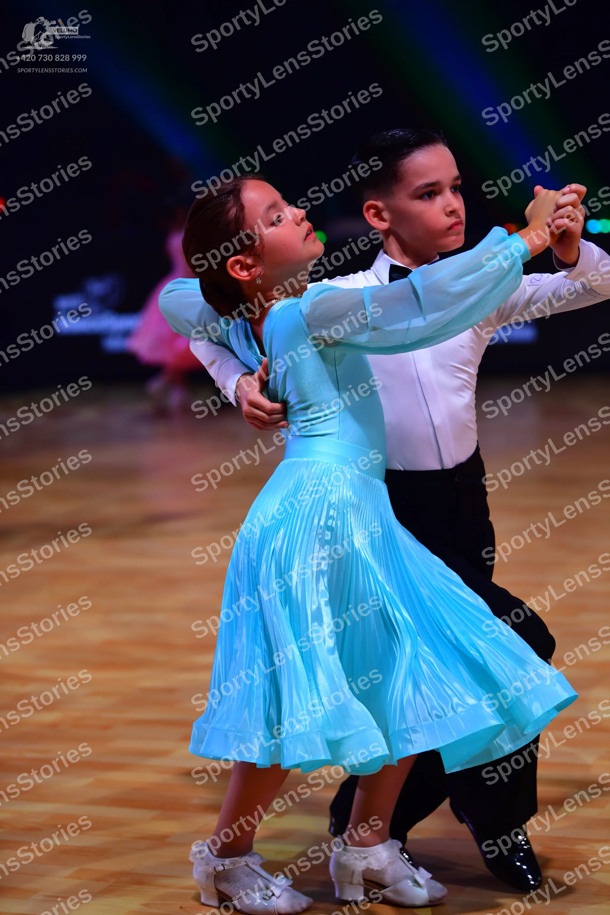 Dancesport competitor: Female dancer: light blue, long-sleeved ballroom dress with a pleated skirt