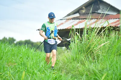 Marathon runner #328: Runner 1: lime green jersey, black shorts, blue cap, blue hydration vest