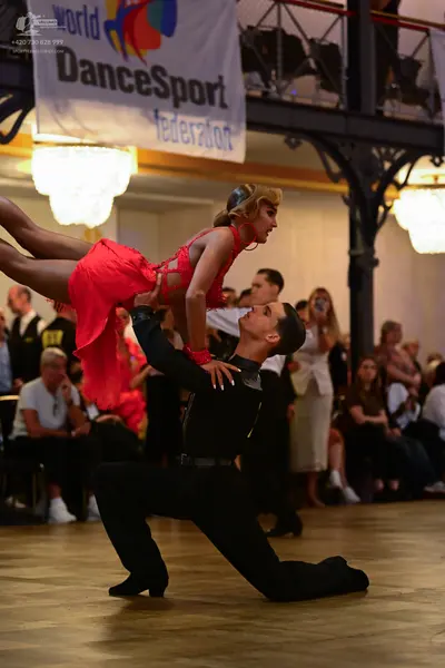 Dancesport competitor: Male dancer: black long-sleeved shirt with sequined shoulder detail and black tr