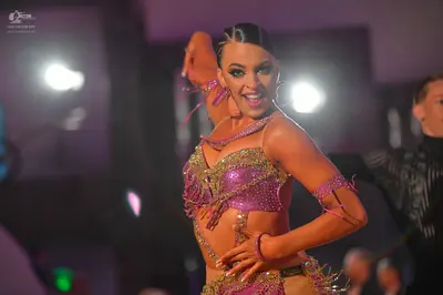 Dancesport competitor: Female dancer: pink/lavender Latin dance costume heavily embellished with sequin
