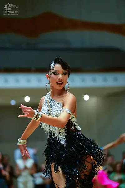 Dancesport competitor: Female dancer: black and silver Latin dress with sequin embellishments and long 