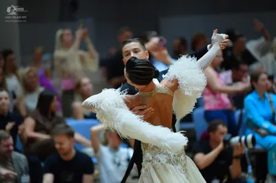 Dancesport competitor: Female dancer: white ballroom dress with large white feather-like decorations on