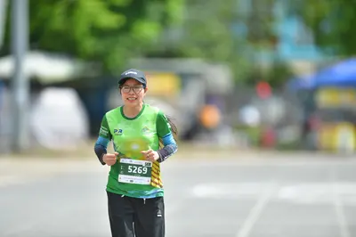 Marathon runner #5269: Runner 1: green and yellow jersey, grey long sleeves, black pants, black cap, gl