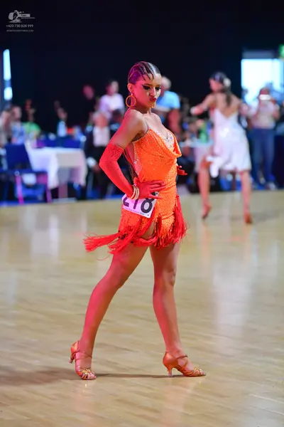 Dancesport competitor #218: Female dancer in foreground: orange latin dress with sequins and fringe