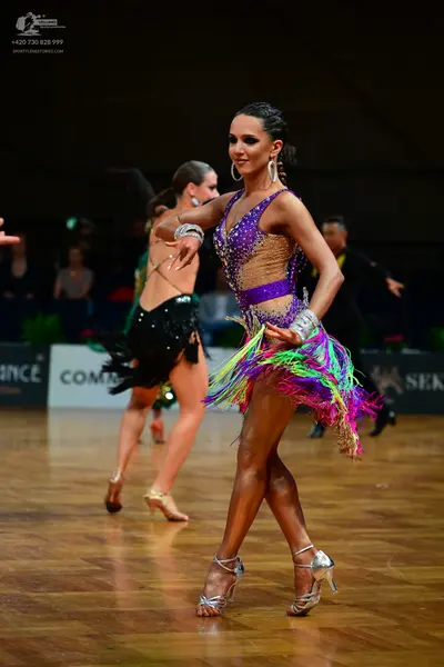 Dancesport competitor: Female dancer (front): purple and lavender Latin dance dress with sequins and mu