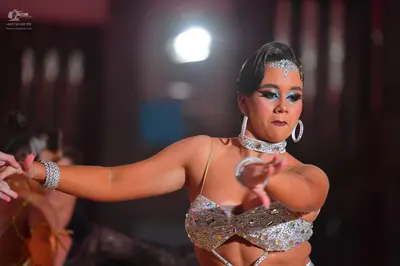 Dancesport competitor: Female dancer: silver/champagne Latin dance costume heavily embellished with rhi