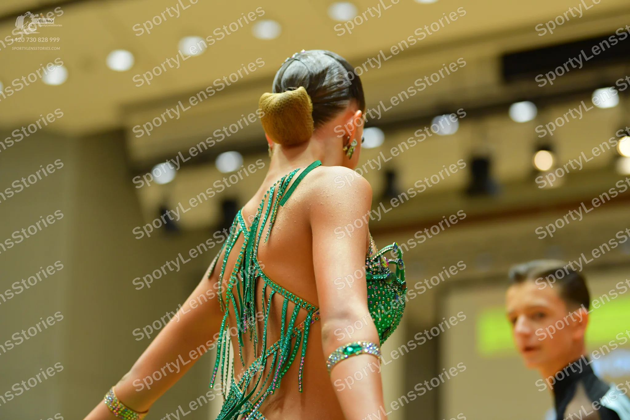 Dancesport competitor: Female dancer: green sequined latin dress with a backless design and long beaded