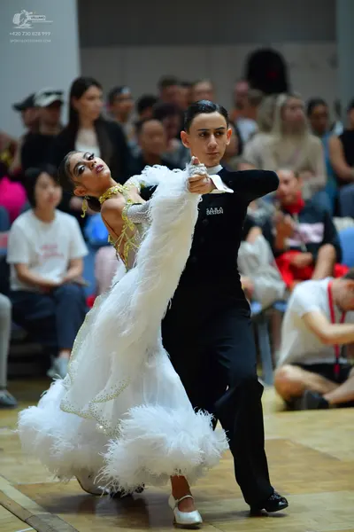 Dancesport competitor: Female dancer: white voluminous ballgown with gold/yellow lace or sequin embelli