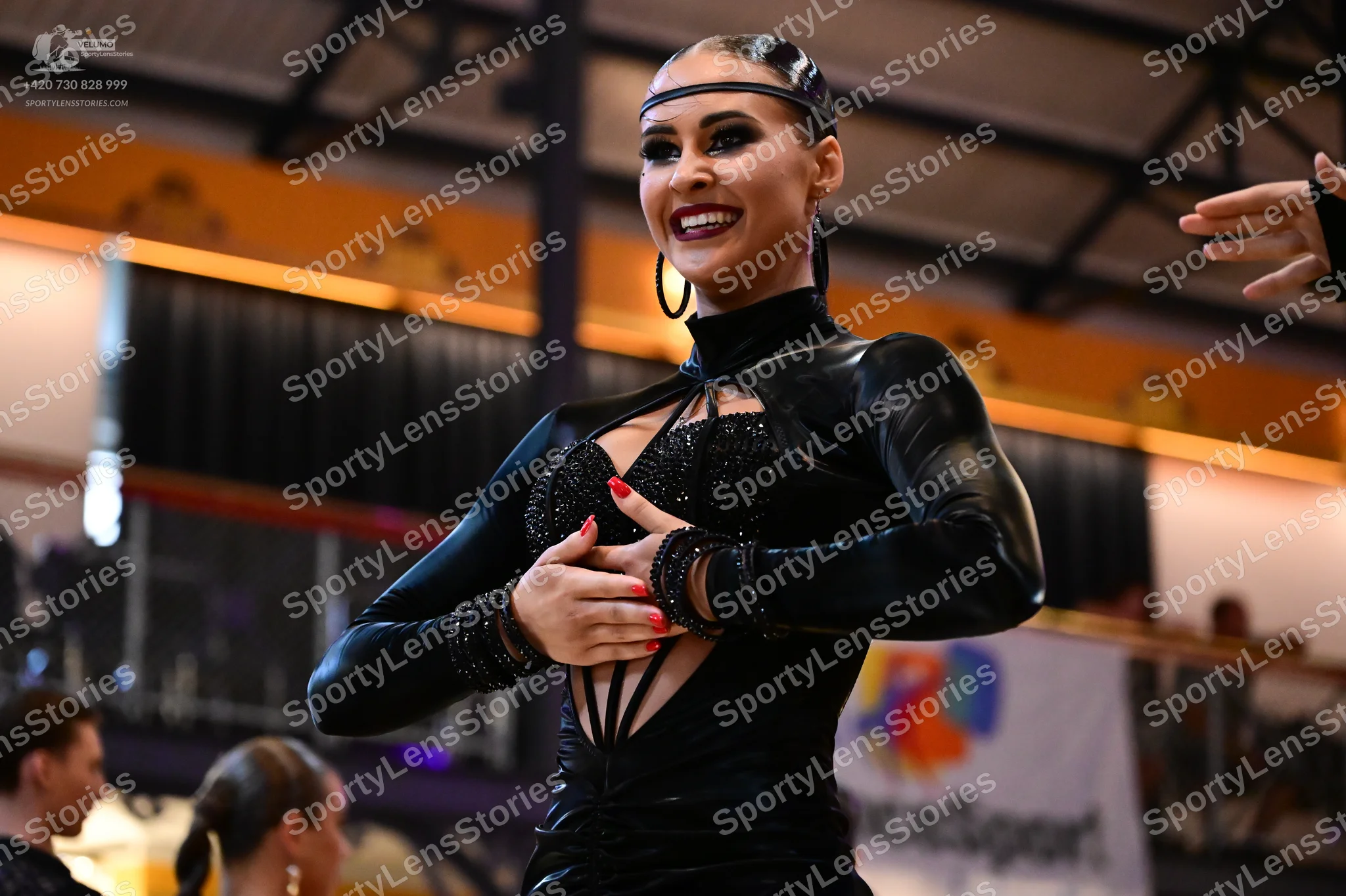 Dancesport competitor: Female dancer: black, long-sleeved latin dress with sequin embellishments on the