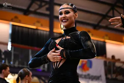 Dancesport competitor: Female dancer: black, long-sleeved latin dress with sequin embellishments on the