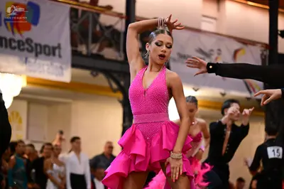 Dancesport competitor #15: Female dancer: bright pink Latin dress with a sequined bodice and a ruffled skir