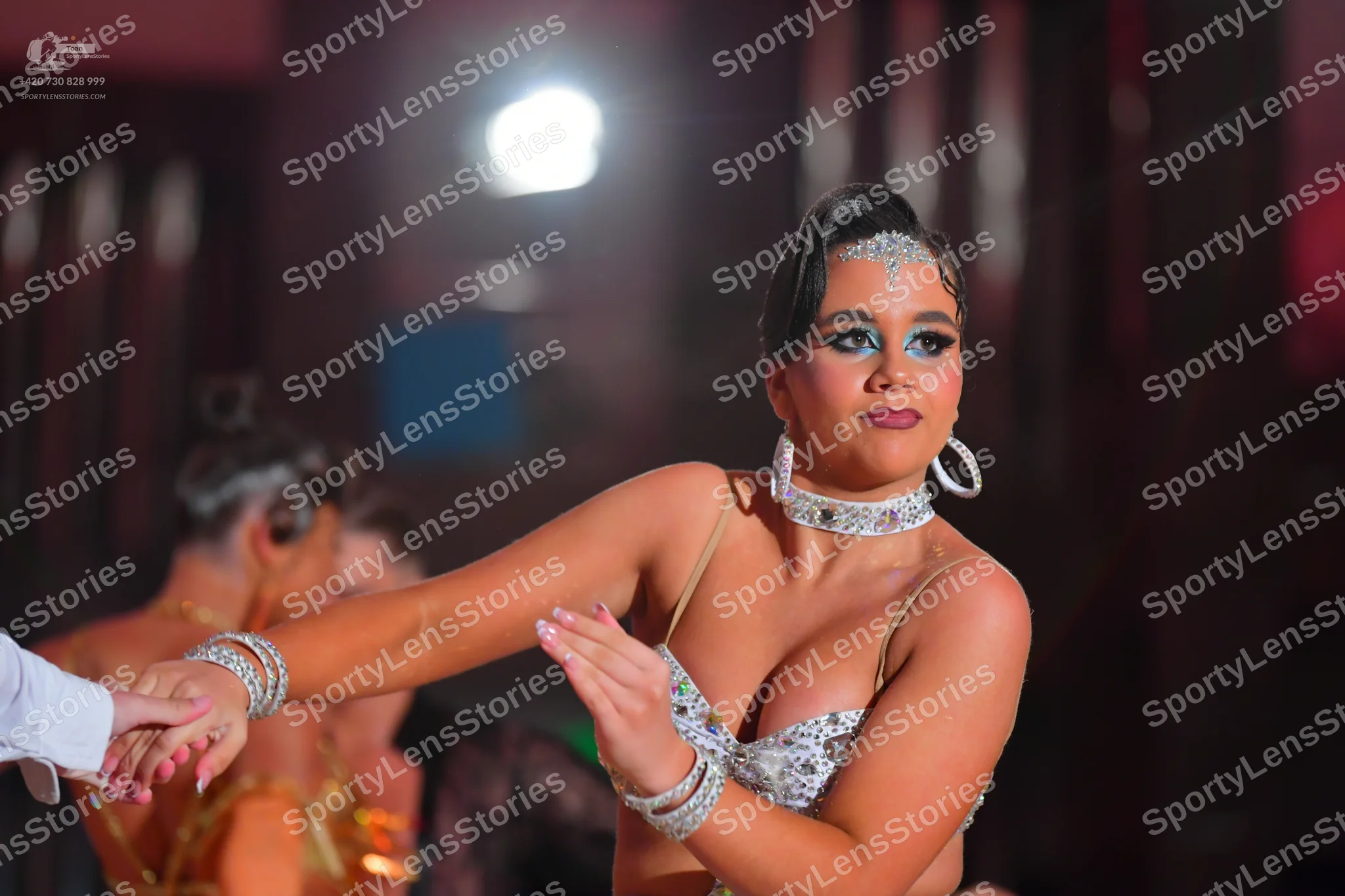 Dancesport competitor: Female dancer: silver/white sequined/crystal-encrusted Latin dance top with thin