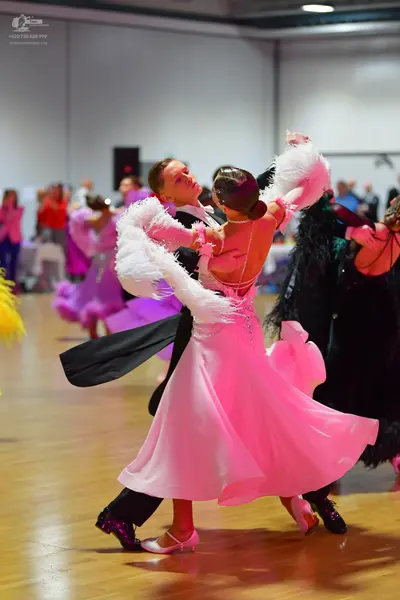 Dancesport competitor: Main female dancer: light pink/blush ballgown with a voluminous, flowing skirt a