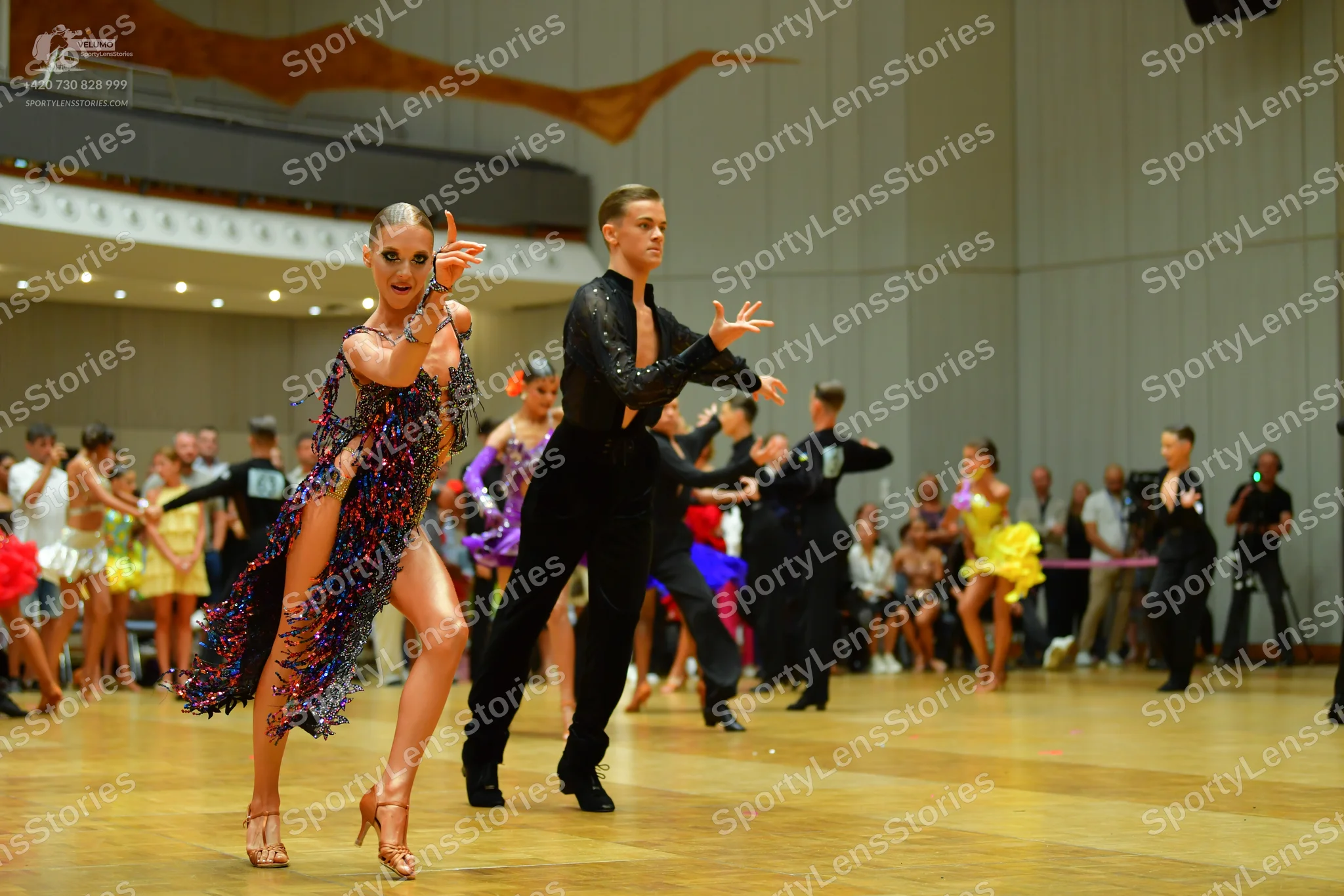 Dancesport competitor: Main female dancer: dark latin dress with multi-colored sequins (purple, blue, p