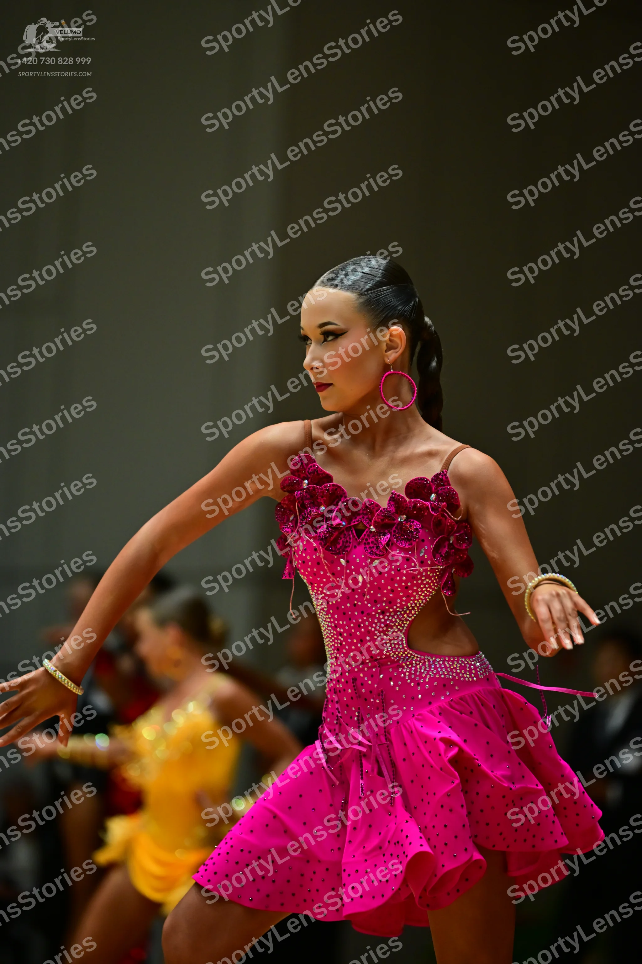 Dancesport competitor: Female dancer in foreground: magenta Latin dance dress with sequins, 3D floral a