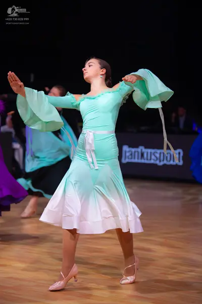 Dancesport competitor: Female dancer: mint green and white ombre latin dress with large, flared bell sl