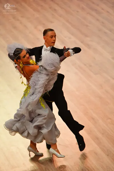 Dancesport competitor: Male dancer: black suit, white shirt, and white bow tie