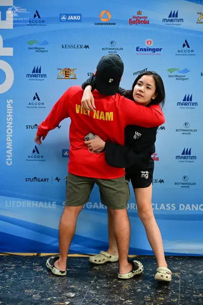 Dancesport competitor: Male dancer: red long-sleeve shirt with "VIET NAM" printed in yellow on the back