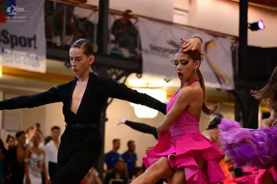 Dancesport competitor: Male dancer: black long-sleeve shirt with a deep V-neckline and black trousers