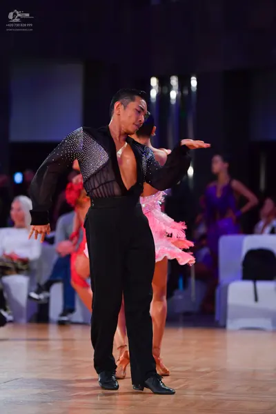 Dancesport competitor: Male dancer: black long-sleeved shirt with a sheer, sequined chest panel and bla