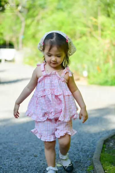 Dancesport competitor: Female dancer: light pink and white gingham sleeveless ruffled top with bows on 