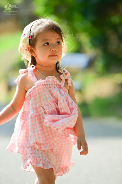 Dancesport competitor: Female dancer: pink and white gingham patterned sleeveless dress with ruffles