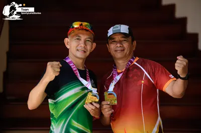 Marathon runner: Runner 1: black jersey with green and white patterns, colorful cap, medal